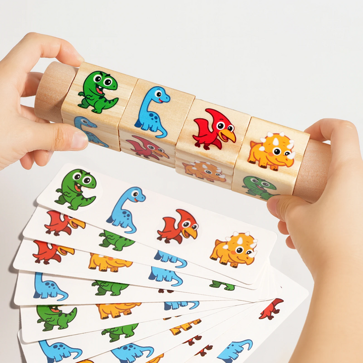 Hands holding a rotating dinosaur cube puzzle over a spread of matching cards