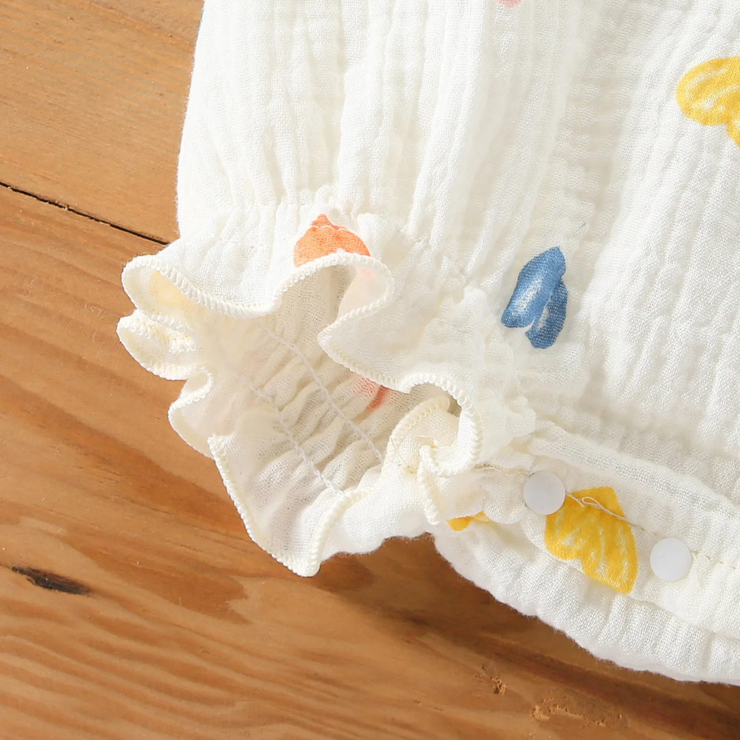 Crotch snap fastener and ruffled edge on the heart-print baby bodysuit
