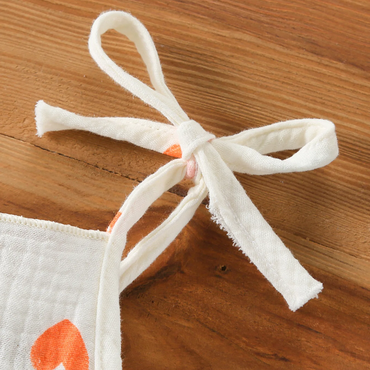 Heart-print bodysuit shoulder strap tied in a bow