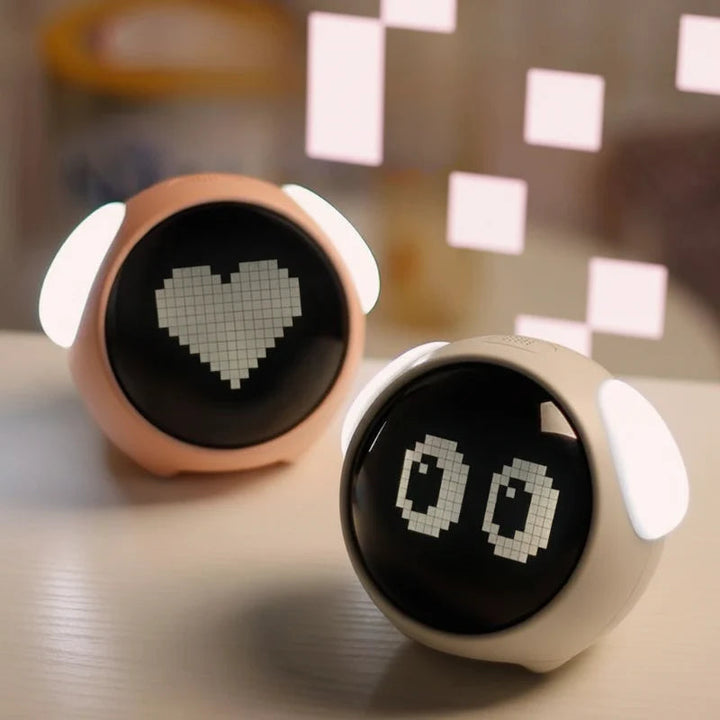 Pink and white alarm clocks with heart and eye displays and illuminated side lights