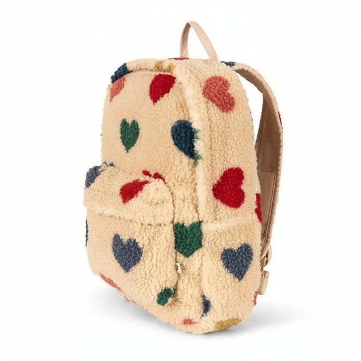 Side view of the beige heart teddy backpack showing its depth and front pocket