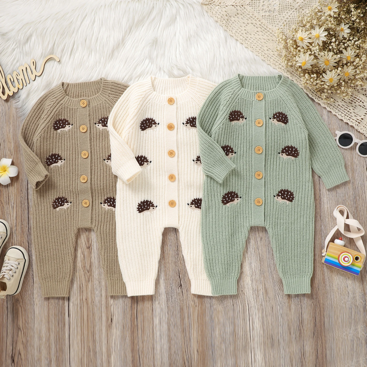 Three hedgehog knit baby jumpsuits in brown, white and green arranged side by side.
