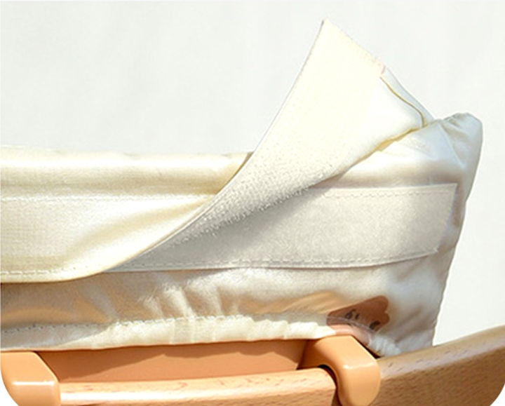 Close-up of the high chair cushion's hook-and-loop fastening and padded fabric edge