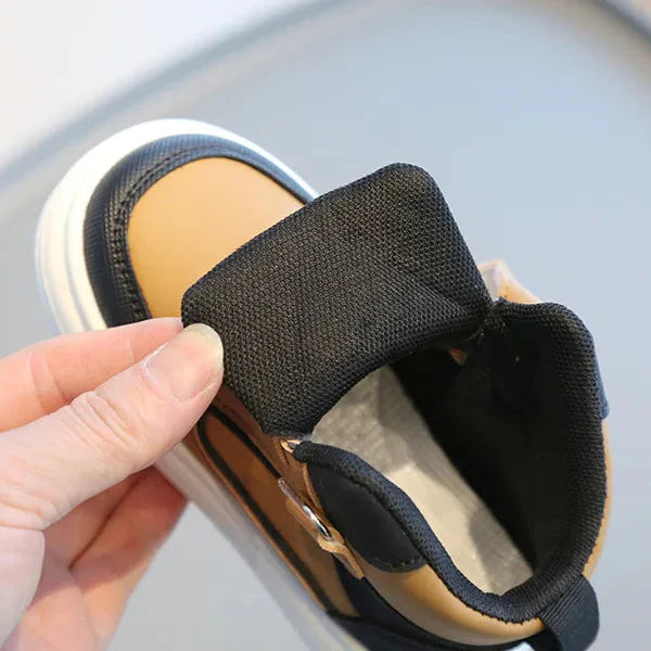 Brown high-top sneaker with the tongue pulled forward to show the lining and padded collar