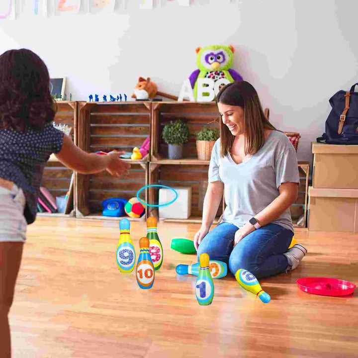 Adult and child playing ring toss with numbered bowling pins indoors