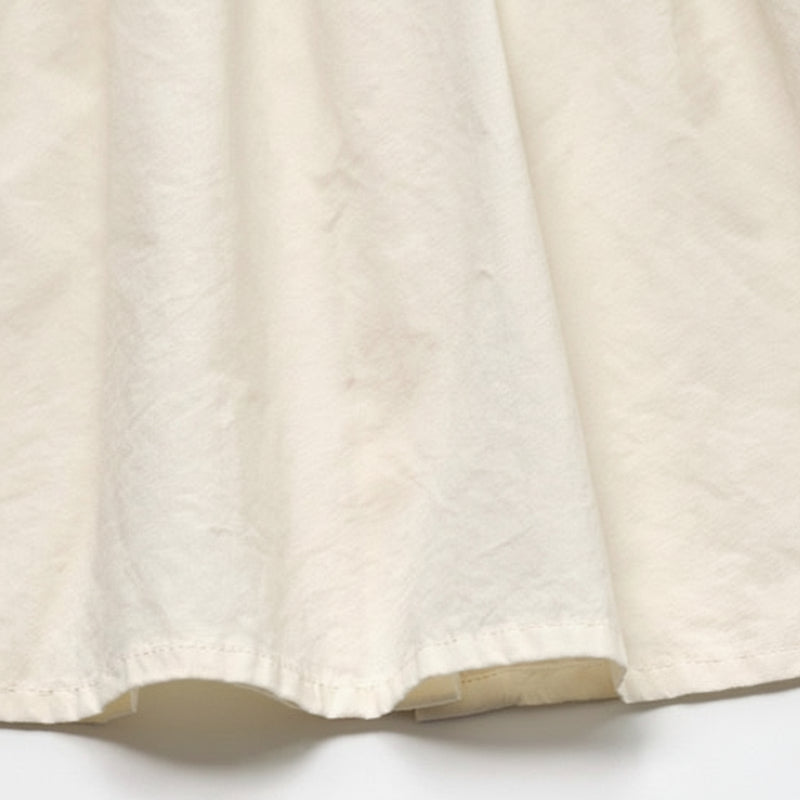 Close-up of the ivory cotton fabric and stitched blouse hem