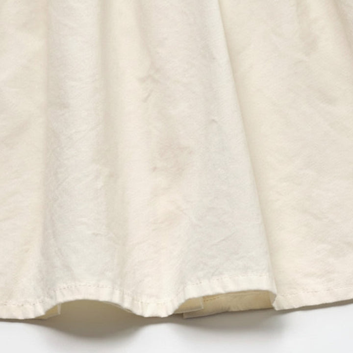 Close-up of the ivory cotton fabric and stitched blouse hem