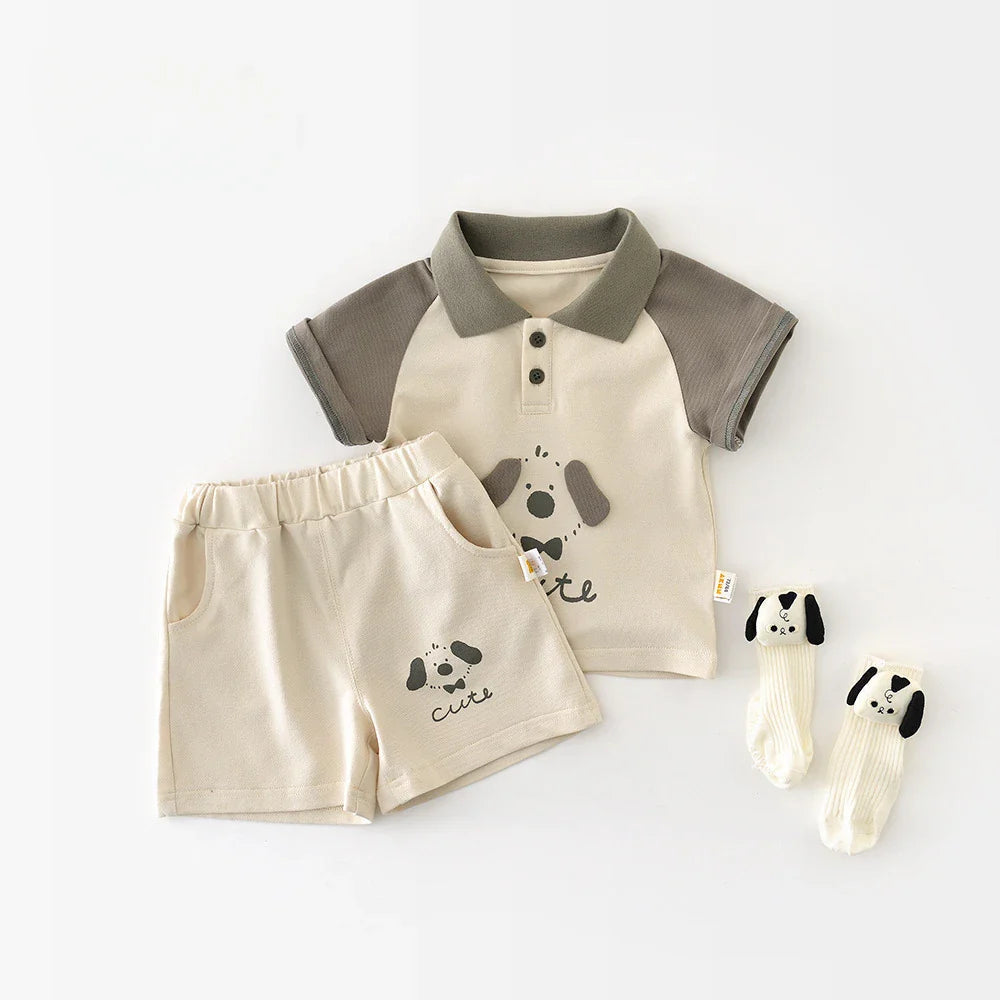 Three-piece ivory and gray baby outfit with a puppy polo, elastic-waist shorts and matching socks