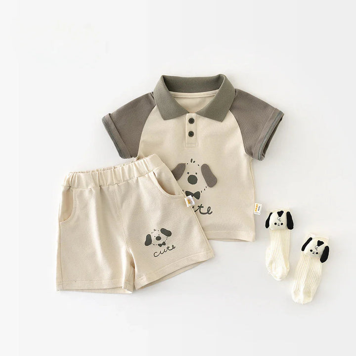 Three-piece ivory and gray baby outfit with a puppy polo, elastic-waist shorts and matching socks