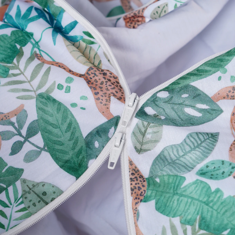 Close-up of the white zipper and leaf-and-animal print on a baby sleep sack