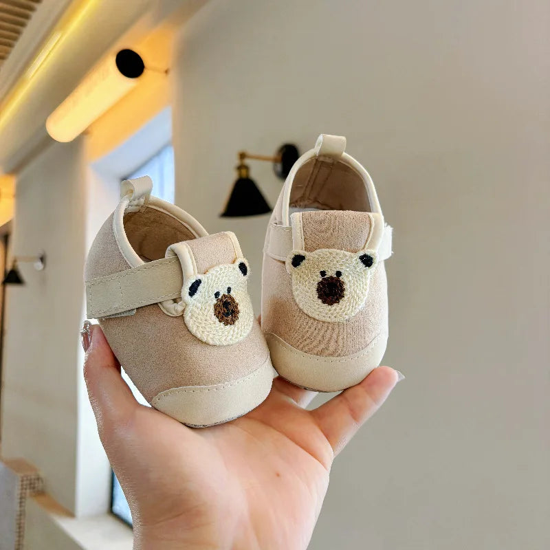 Pair of khaki baby shoes with bear patches and hook-and-loop straps