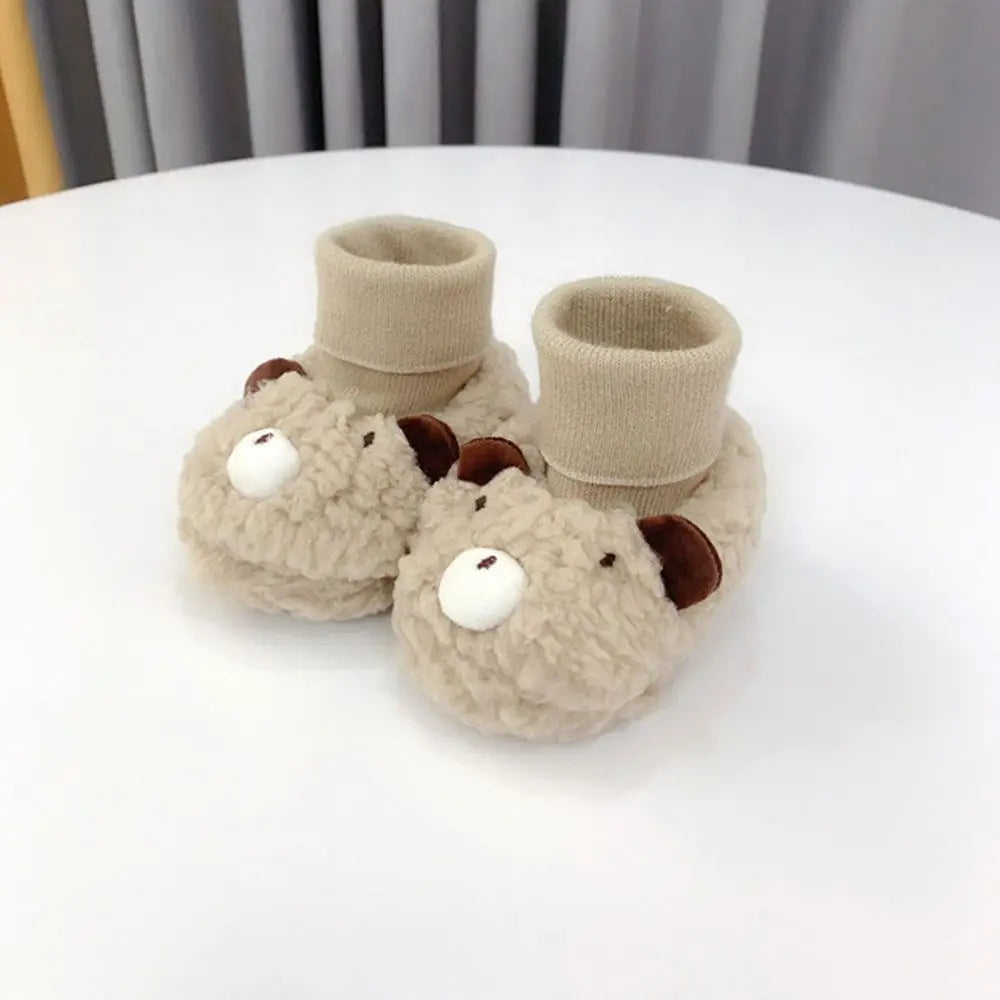 Khaki bear baby slippers with brown ears, white muzzles, and textured uppers
