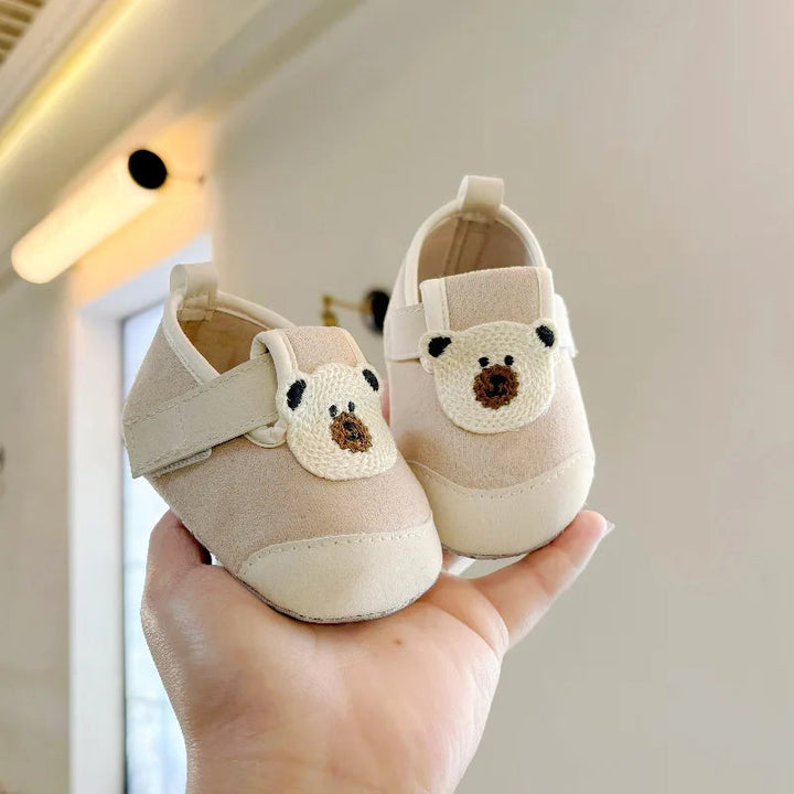 Front view of khaki baby shoes with bear faces and cream toe caps