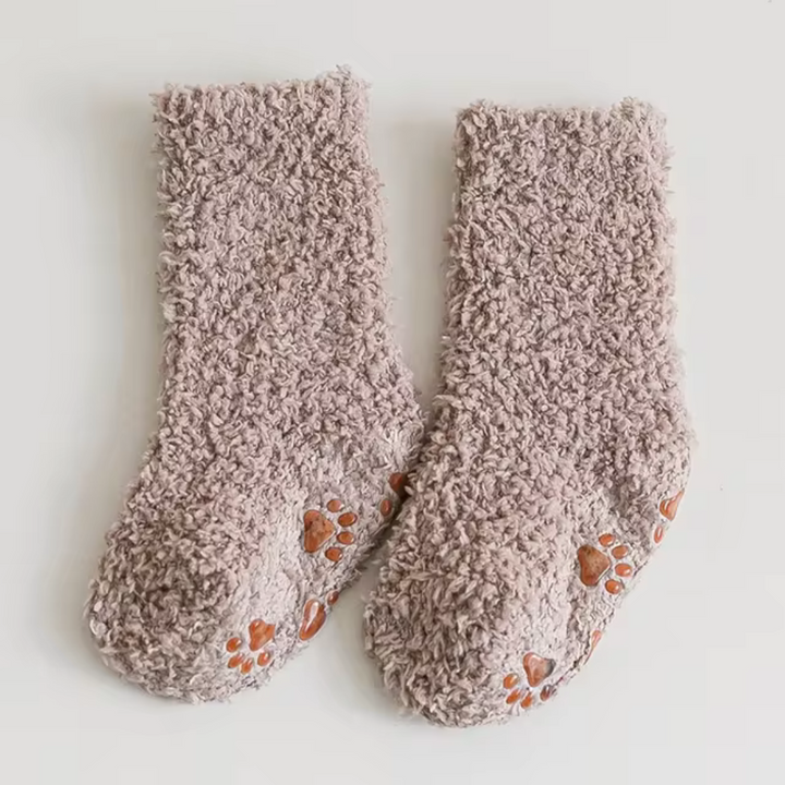 Khaki fleece socks with orange paw-print patterns on the soles.