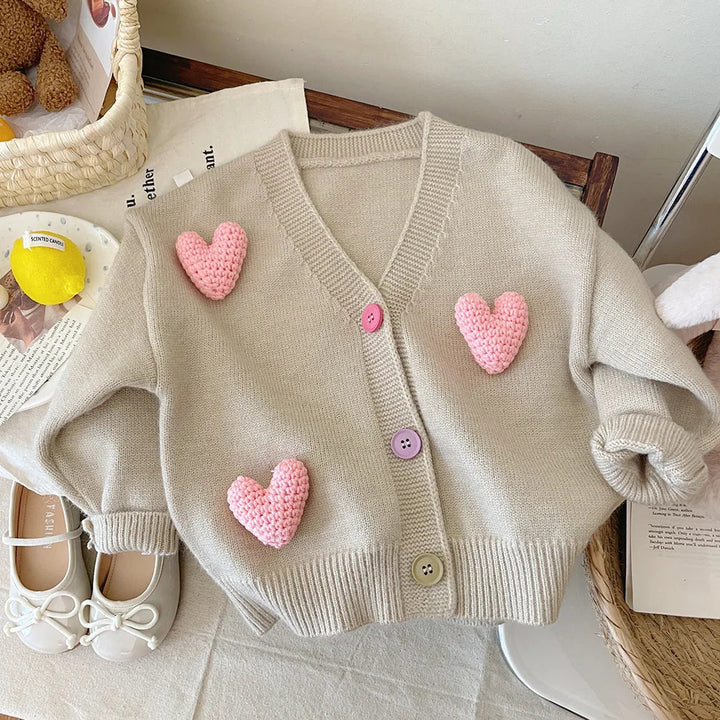 Khaki cardigan with raised pink hearts, a V-neck, and ribbed trim