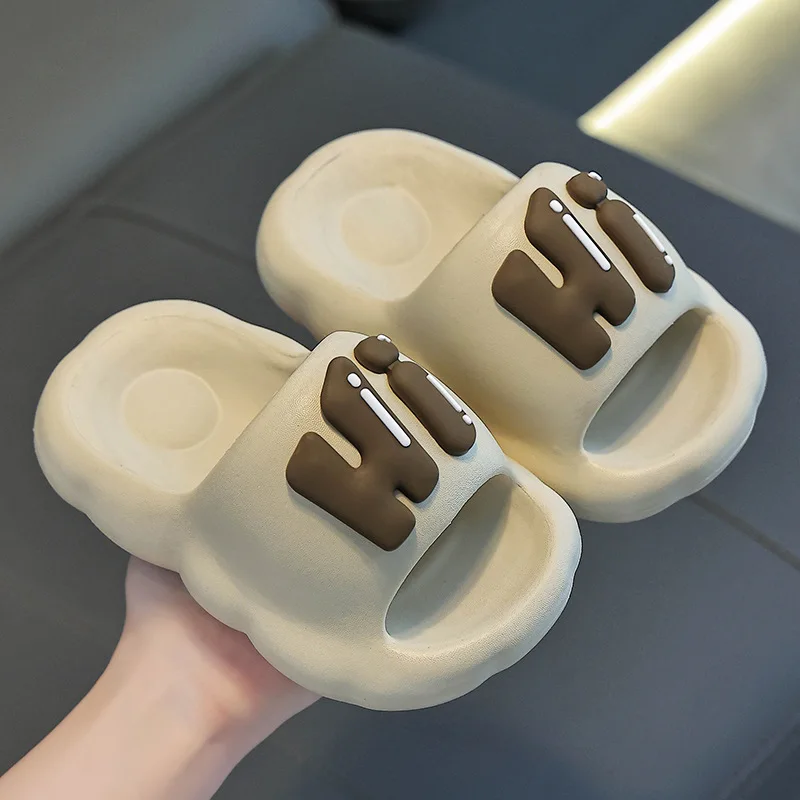 Khaki slide slippers with raised brown Hi lettering.