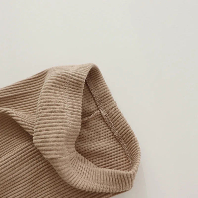 Close-up of the elastic waistband and ribbed cotton fabric on khaki leggings.