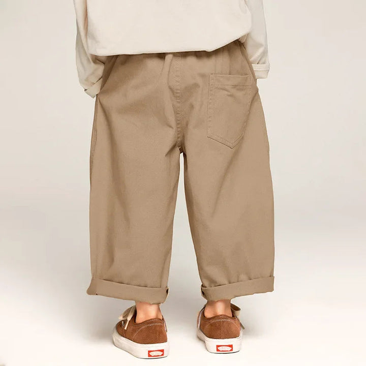 Back view of khaki pants showing patch pockets, a relaxed fit, and rolled cuffs.