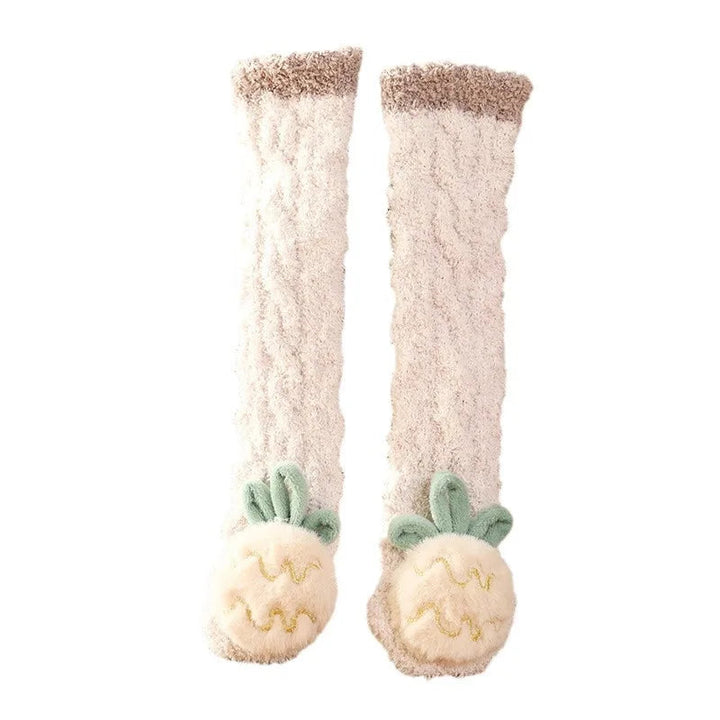 Beige long baby socks with pineapple details and darker cuffs on a white background.