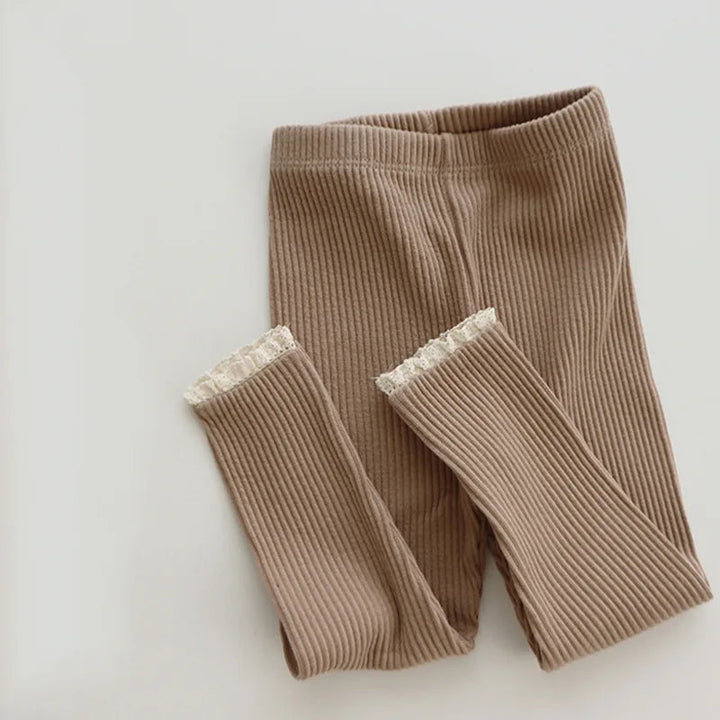 Front view of khaki ribbed leggings with folded legs and cream lace trim.