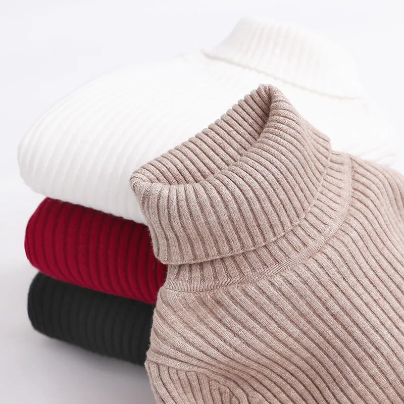 Close-up of a khaki fold-over turtleneck collar with stacked sweaters behind it