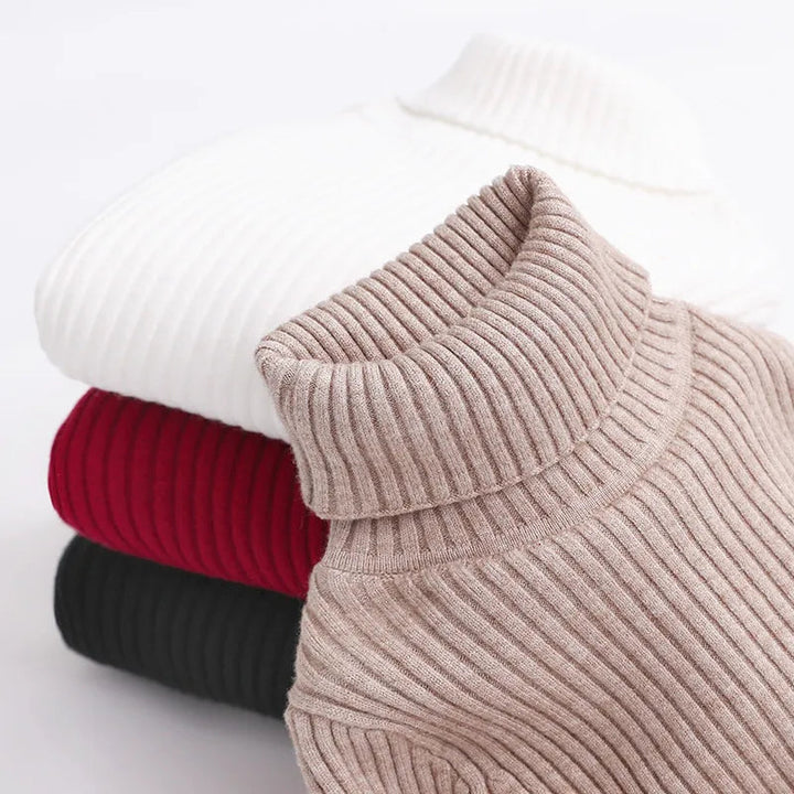 Close-up of a khaki fold-over turtleneck collar with stacked sweaters behind it