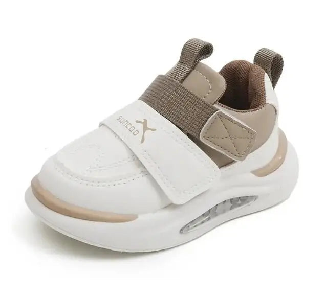 Close-up of a khaki and white sneaker with a wide front strap and two pull tabs