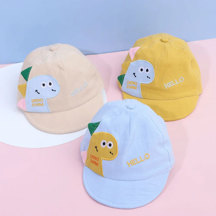 Khaki, yellow, and blue dinosaur caps arranged on a pink surface.