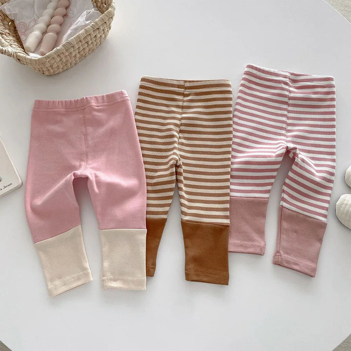 Back view of three leggings styles with elastic waistbands and contrasting ankle cuffs