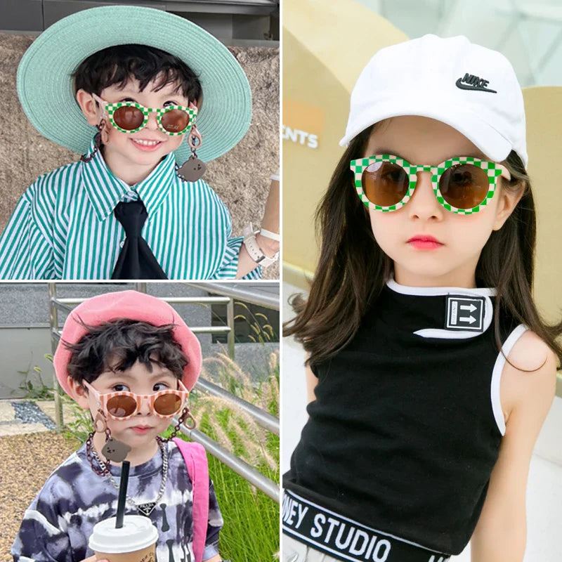Children wearing green checkered and pale pink round sunglasses.