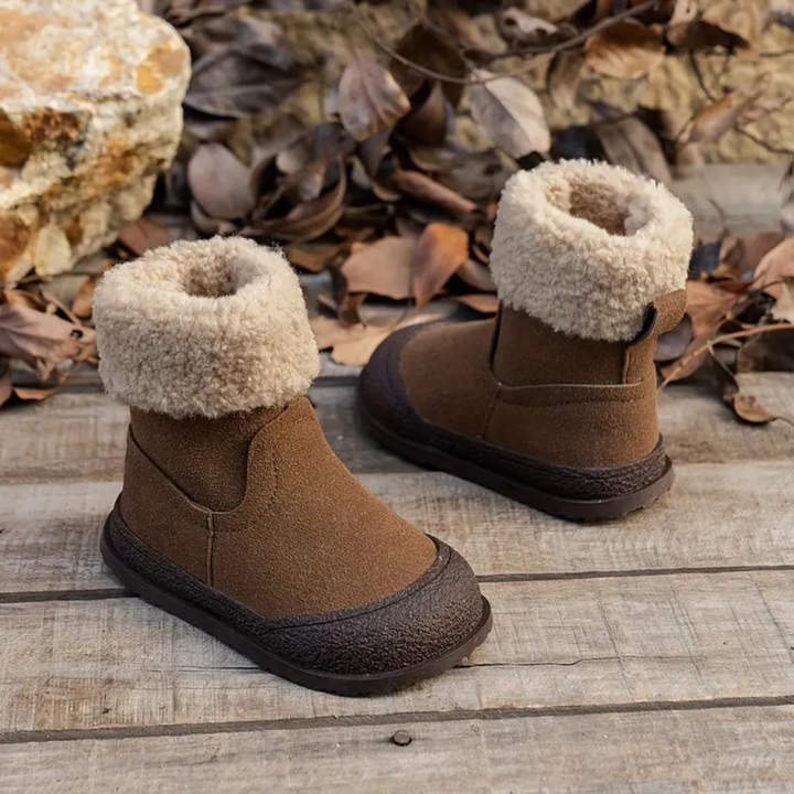 Angled view of brown winter boots showing the tall shafts, cream fleece cuffs, and dark soles.