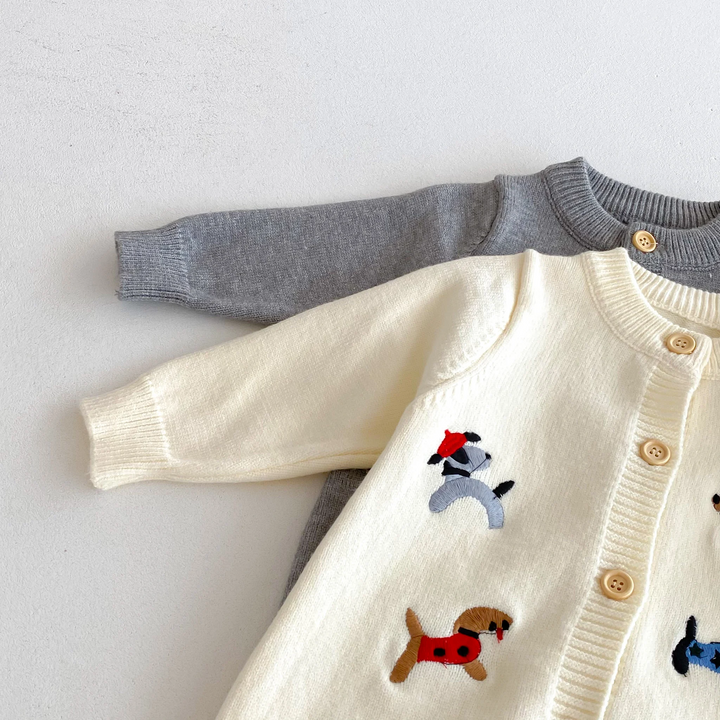 Close-up of knit baby jumpsuit sleeves, ribbed cuffs, and front button detail