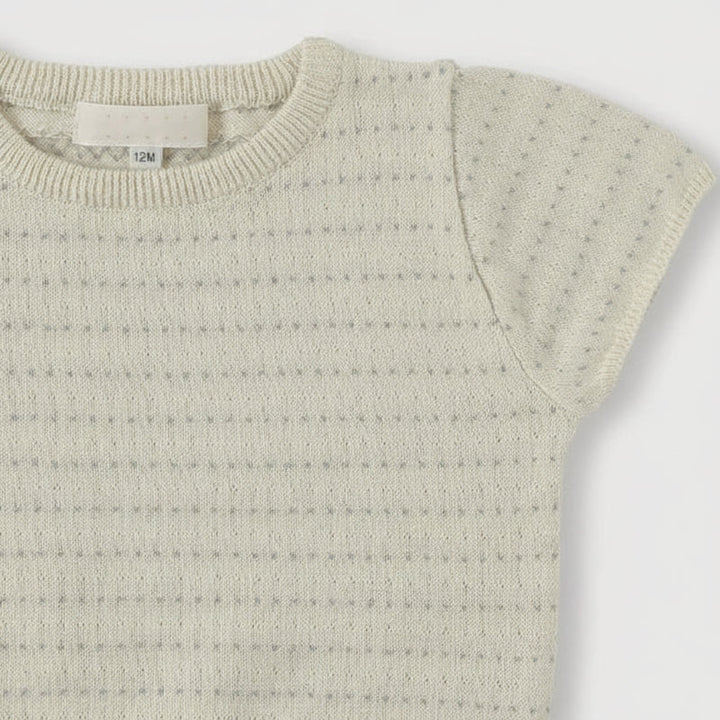 Close-up of the round ribbed neckline and openwork knit on a short-sleeve top