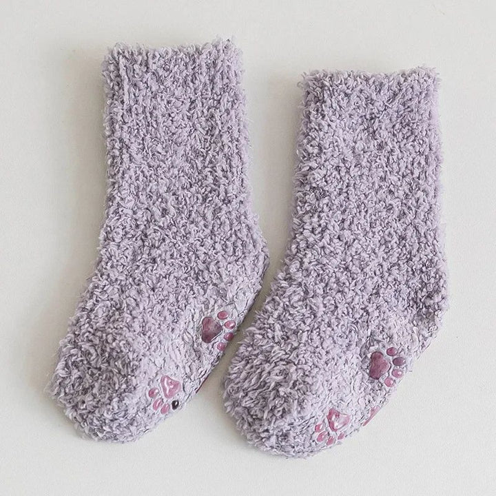 Lavender fleece socks laid flat with paw-print sole details.