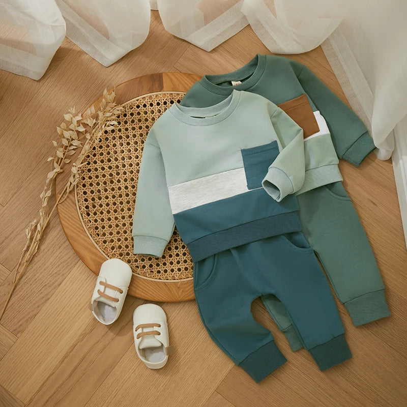 Two green colorblock tracksuit sets layered on a woven tray