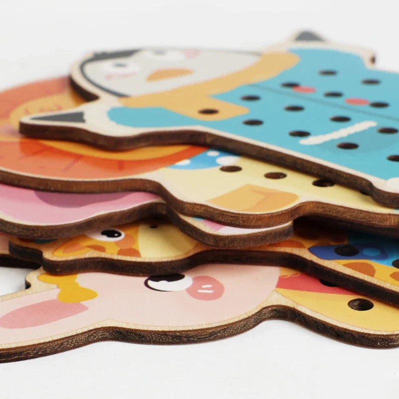 Stacked wooden animal lacing boards showing their edges and threading holes