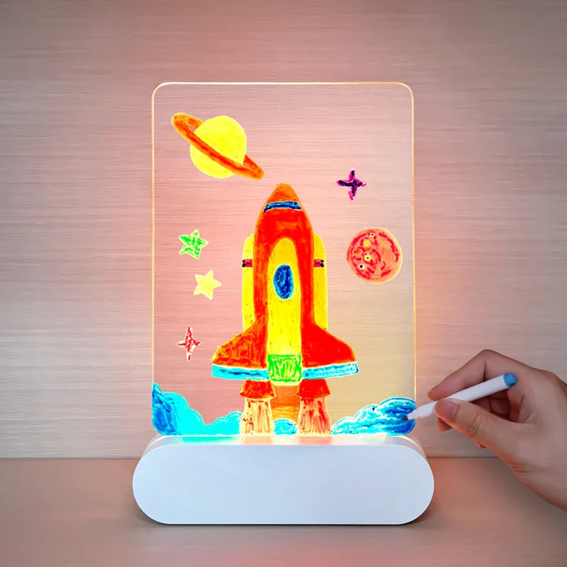 Hand coloring a rocket drawing on an illuminated board with planet and star designs