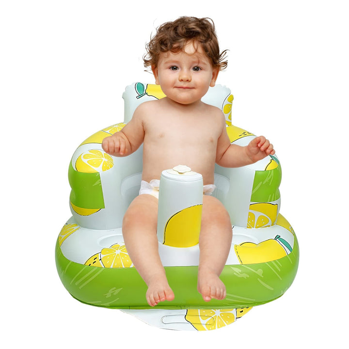 Front view of a child sitting in a green and yellow lemon-print inflatable baby seat.