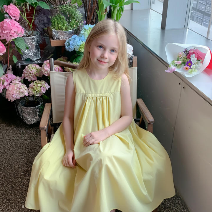 Front view of a girl wearing the yellow A-line dress with a gathered bodice