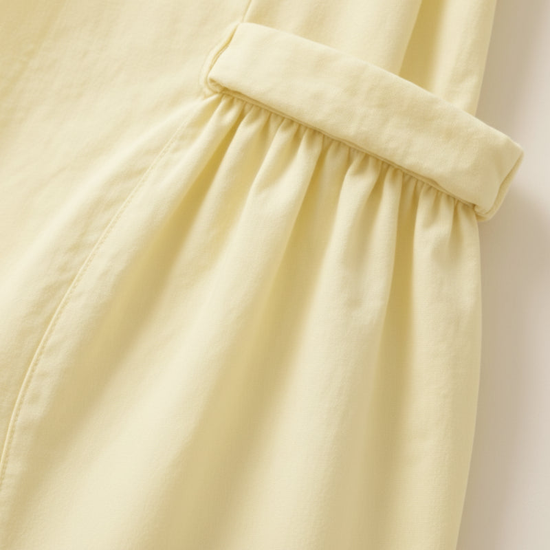 Close-up of the gathered opening on a yellow dress pocket