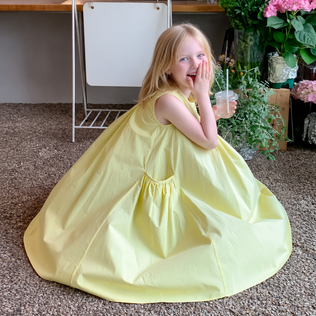 Side view of the yellow dress showing its roomy skirt and gathered pocket