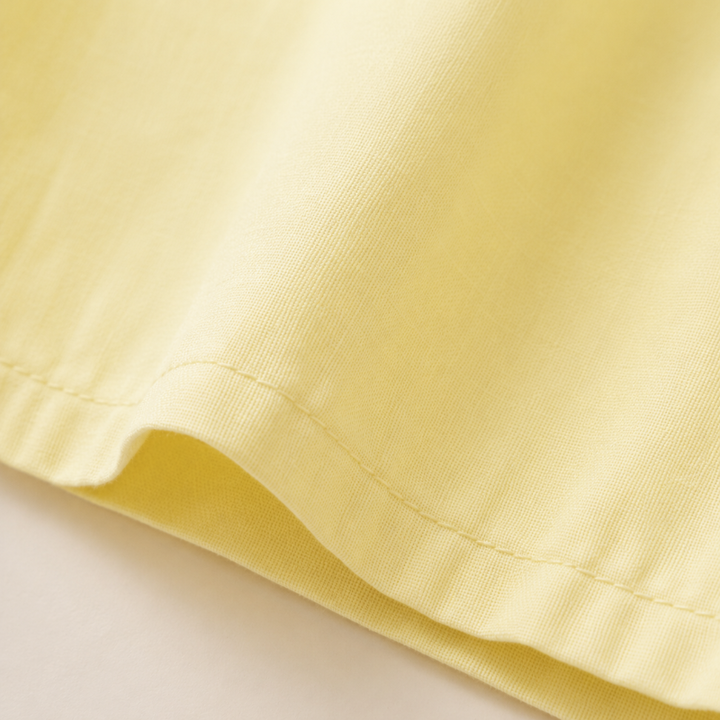 Close-up of the folded hem and stitching on the yellow dress