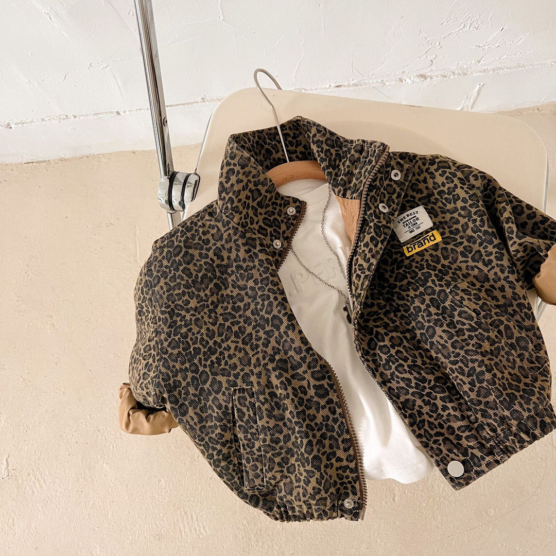 Overhead view of a leopard print jacket with turned-up cuffs arranged on a chair