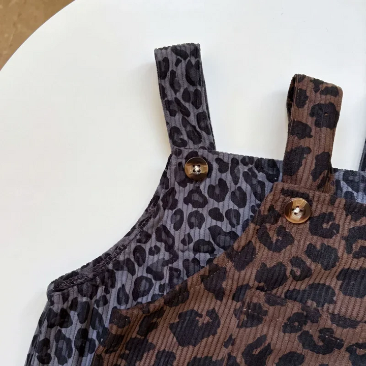Close-up of button-fastening straps on brown and gray leopard print overalls