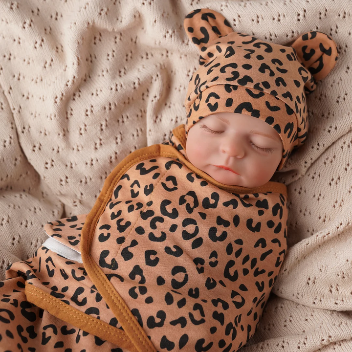 Doll wearing a leopard-print wrap and matching hat with rounded ears.