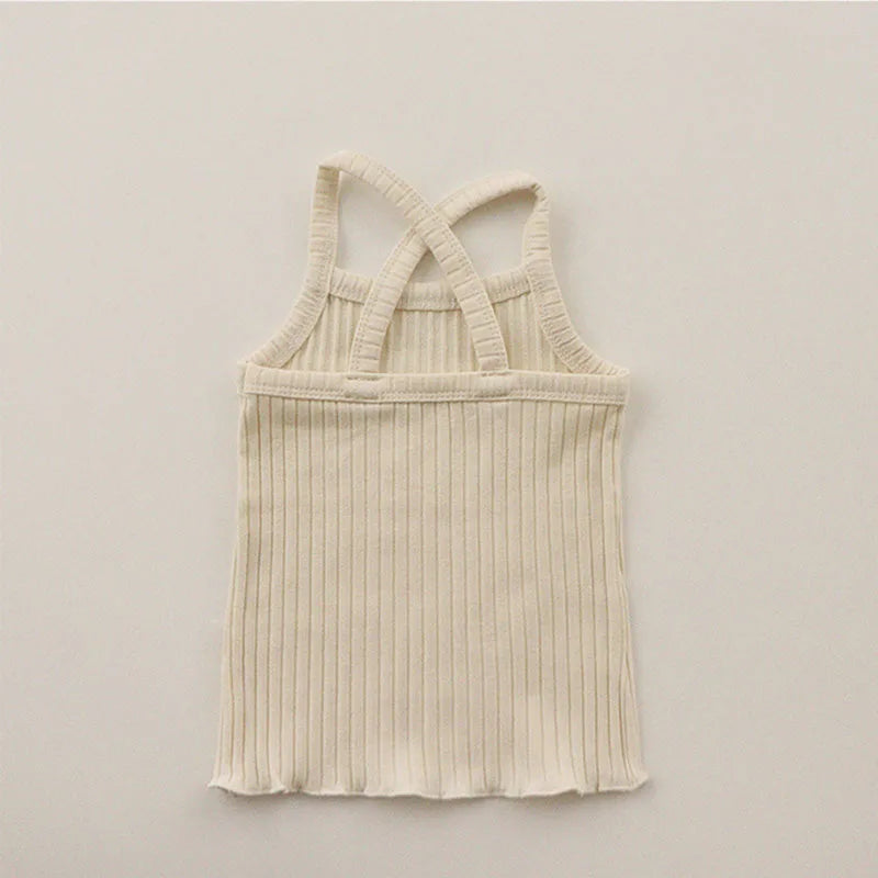 Back of the light beige ribbed pajama tank with crossed straps and a wavy hem