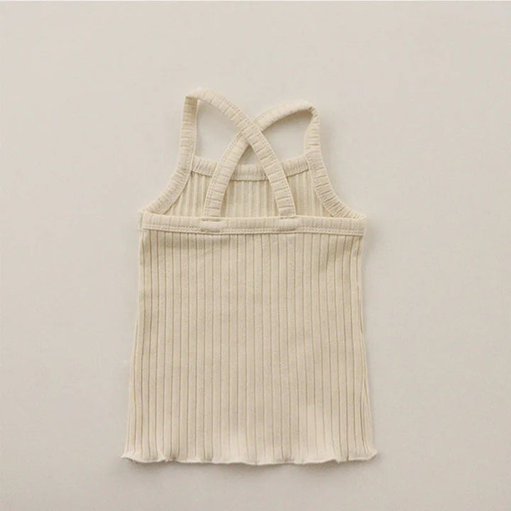 Back of the light beige ribbed pajama tank with crossed straps and a wavy hem