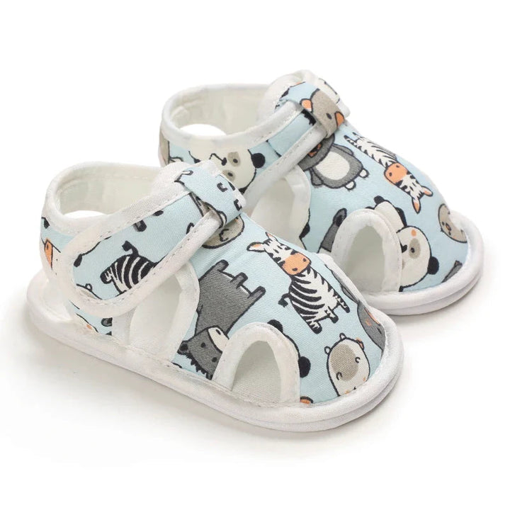 Pair of light blue baby sandals with animal prints, white trim and ankle straps