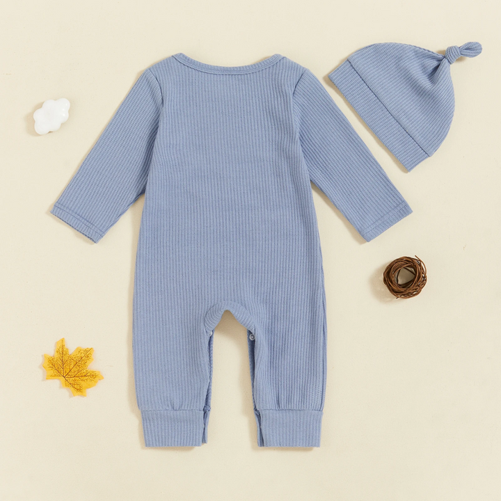Back of a light blue long-sleeve baby jumpsuit beside its matching beanie