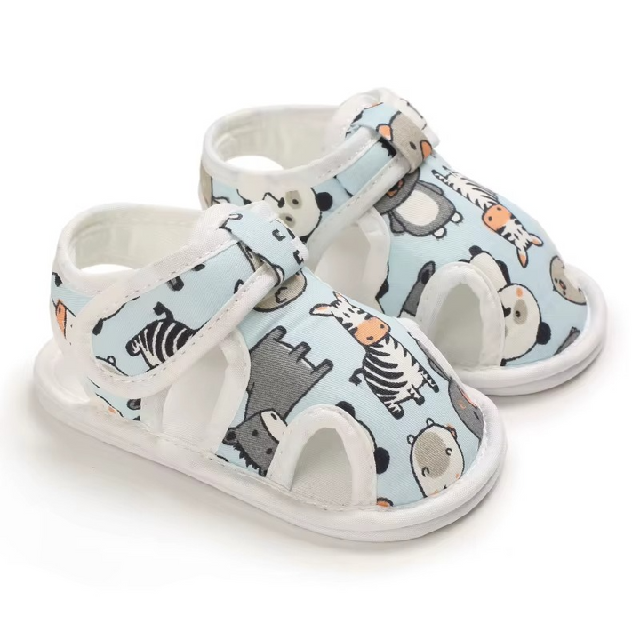 Light blue baby sandals with animal characters and white edging, viewed at an angle